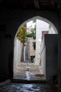 Beyaz boyanmış duvarları, taş kaldırımları olan dar bir tüneli ve Yunanistan 'daki Yunan adalarında büyüleyici bir Akdeniz atmosferi yaratan resimli bir ara sokak.