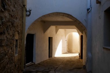 Beyaz boyanmış duvarları, taş kaldırımları olan dar bir tüneli ve Yunanistan 'daki Yunan adalarında büyüleyici bir Akdeniz atmosferi yaratan resimli bir ara sokak.