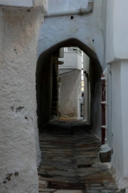 Beyaz boyanmış duvarları, taş kaldırımları olan dar bir tüneli ve Yunanistan 'daki Yunan adalarında büyüleyici bir Akdeniz atmosferi yaratan resimli bir ara sokak.