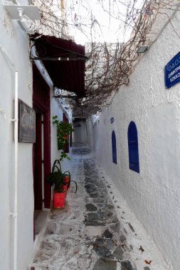 Beyaz boyanmış duvarları, taş kaldırımları olan dar bir tüneli ve Yunanistan 'daki Yunan adalarında büyüleyici bir Akdeniz atmosferi yaratan resimli bir ara sokak.