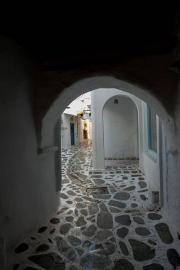 Beyaz boyanmış duvarları, taş kaldırımları olan dar bir tüneli ve Yunanistan 'daki Yunan adalarında büyüleyici bir Akdeniz atmosferi yaratan resimli bir ara sokak.