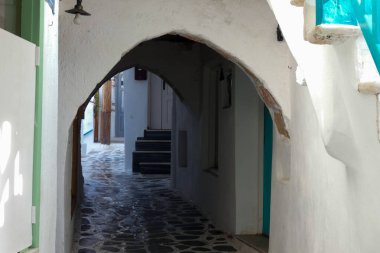 Beyaz boyanmış duvarları, taş kaldırımları olan dar bir tüneli ve Yunanistan 'daki Yunan adalarında büyüleyici bir Akdeniz atmosferi yaratan resimli bir ara sokak.