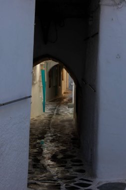 Beyaz boyanmış duvarları, taş kaldırımları olan dar bir tüneli ve Yunanistan 'daki Yunan adalarında büyüleyici bir Akdeniz atmosferi yaratan resimli bir ara sokak.