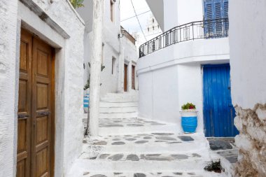 Açık mavi ahşap kapılı oval pencereli ve Yunanistan 'da beyazlatılmış bir evde fener.