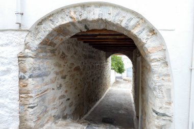 Beyaz boyanmış duvarları, taş kaldırımları olan dar bir tüneli ve Yunanistan 'daki Yunan adalarında büyüleyici bir Akdeniz atmosferi yaratan resimli bir ara sokak.