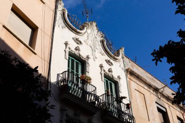 Paslı metal parmaklıklar eski bir duvarın kapalı kahverengi penceresini grafiti ile koruyor.