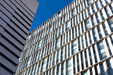 Güneşli bir günde tekrarlayan mimari elementlerle modern yapı cephesi