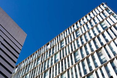 Güneşli bir günde tekrarlayan mimari elementlerle modern yapı cephesi