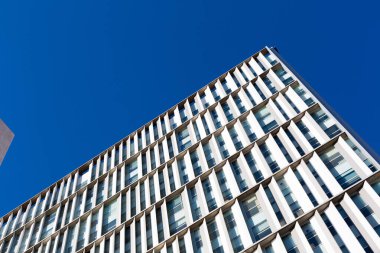 Güneşli bir günde tekrarlayan mimari elementlerle modern yapı cephesi