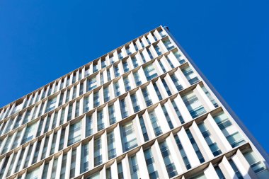 Güneşli bir günde tekrarlayan mimari elementlerle modern yapı cephesi