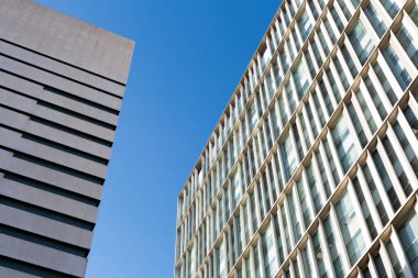 Güneşli bir günde tekrarlayan mimari elementlerle modern yapı cephesi