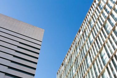 Güneşli bir günde tekrarlayan mimari elementlerle modern yapı cephesi