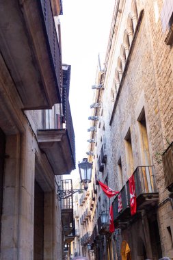 Barselona 'nın Gotik Mahallesi' ndeki dar bir sokakta balkonlardan sarkan katalan bayrakları, İspanya