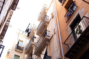 Barselona 'nın Gotik Mahallesi' ndeki dar bir sokakta balkonlardan sarkan katalan bayrakları, İspanya