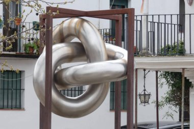 Aracena, Huelva, Endülüs, İspanya 'daki beyaz binalar arasında yokuş yukarı giden dar bir kaldırım taşı caddesi.