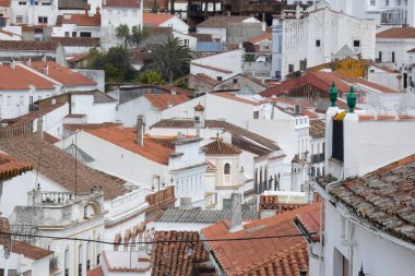 Aracena, Huelva, Endülüs, İspanya 'daki beyaz binalar arasında yokuş yukarı giden dar bir kaldırım taşı caddesi.