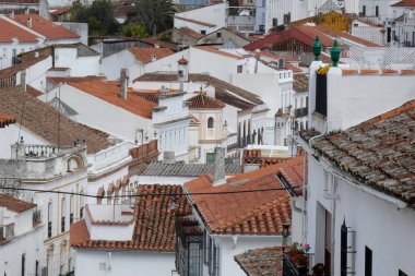 Aracena, Huelva, Endülüs, İspanya 'daki beyaz binalar arasında yokuş yukarı giden dar bir kaldırım taşı caddesi.