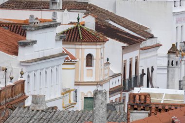 Aracena, Huelva, Endülüs, İspanya 'daki beyaz binalar arasında yokuş yukarı giden dar bir kaldırım taşı caddesi.