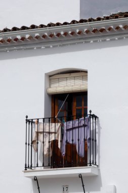 Aracena, Huelva, Endülüs, İspanya 'daki beyaz binalar arasında yokuş yukarı giden dar bir kaldırım taşı caddesi.