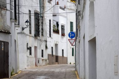 Aracena, Huelva, Endülüs, İspanya 'daki beyaz binalar arasında yokuş yukarı giden dar bir kaldırım taşı caddesi.