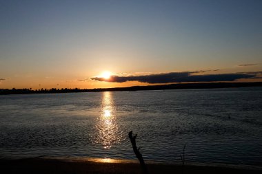 Kuşlar güzel bir altın saat boyunca uçuyor. Karanlık bulutlar ve parlak merceklerle gün batımında.