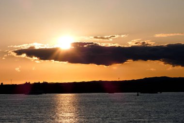 Kuşlar güzel bir altın saat boyunca uçuyor. Karanlık bulutlar ve parlak merceklerle gün batımında.