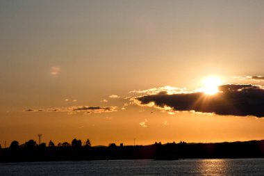 Kuşlar güzel bir altın saat boyunca uçuyor. Karanlık bulutlar ve parlak merceklerle gün batımında.