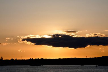 Kuşlar güzel bir altın saat boyunca uçuyor. Karanlık bulutlar ve parlak merceklerle gün batımında.