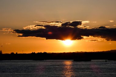 Kuşlar güzel bir altın saat boyunca uçuyor. Karanlık bulutlar ve parlak merceklerle gün batımında.