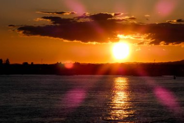 Kuşlar güzel bir altın saat boyunca uçuyor. Karanlık bulutlar ve parlak merceklerle gün batımında.