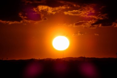 Kuşlar güzel bir altın saat boyunca uçuyor. Karanlık bulutlar ve parlak merceklerle gün batımında.