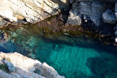 Akdeniz 'in saydam sularından çıkan yosunlu kayalık kayalıklar.