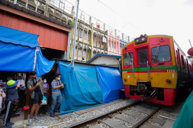 Mae Klong, Samut Sakhon / Tayland - 22 Ekim 2022: Mae Klong tren istasyonu demiryolu pazarı ile yerel halk yaşamı. Samut Sakhon 'da ulaşımla Talad Rom Hoop pazarında turizm.