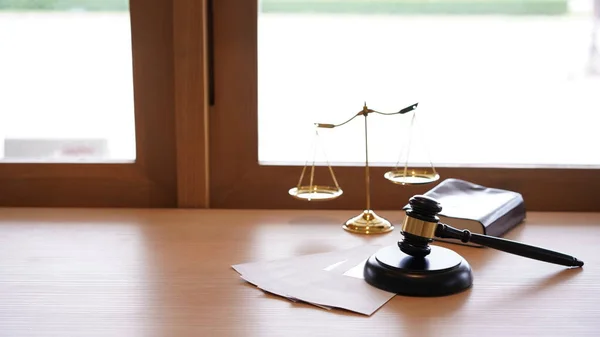 Lawyer or judge's hammer in the court. Auction's hammer and judgement golden scale are on wood table. Law subject. Judgement subject to judge people.
