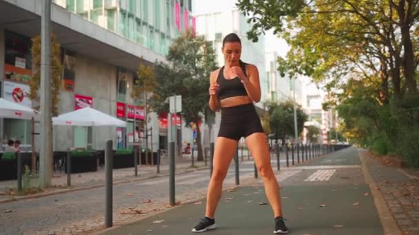 Kadın Koşuya Başlamadan Önce Parkın Yakınındaki Pistte Bacaklarını Isıtıyor Orta — Stok video