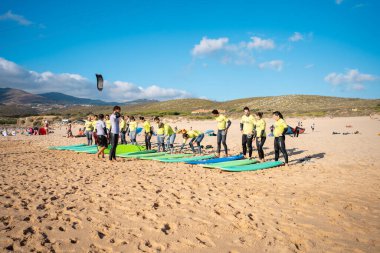 Portekiz, Sintra, Ağustos 2022 Praia da Guincho Sörf tahtası öğrencilerinden oluşan bir grup Atlantik Okyanusu 'nda dalgalarda sörf eğitimi alıyor. Sahilde sörf dersleri.