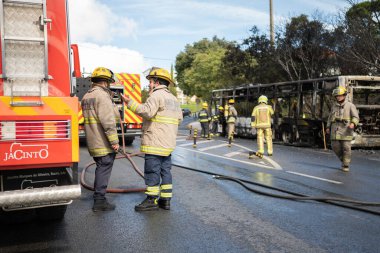 Portugal, Odivelas 07 September 2022 Rescue Team of Firefighters Arrive on the Car Crash fired passenger bus Traffic Accident Scene. Firemen fire department fight with fire on road. Accident disaster