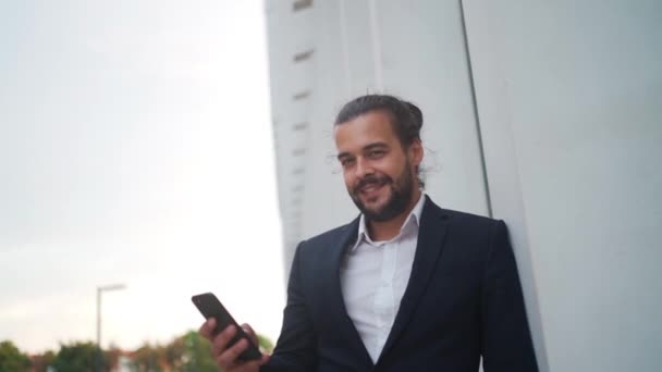 Przystojny Stylowy Biznesmen Przeglądający Swój Smartfon Pobliżu Nowoczesnego Biurowca Atrakcyjny — Wideo stockowe