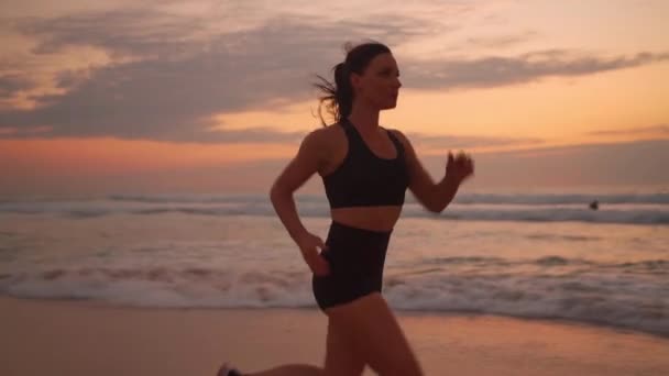 Mujer Atlética Con Pelo Ondulado Corriendo Playa Dramático Fondo Del — Vídeos de Stock