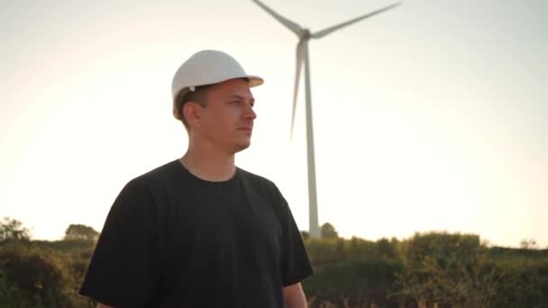 Engineer Man White Hard Hat Walking Field Huge Windmills Summer — Vídeo de stock