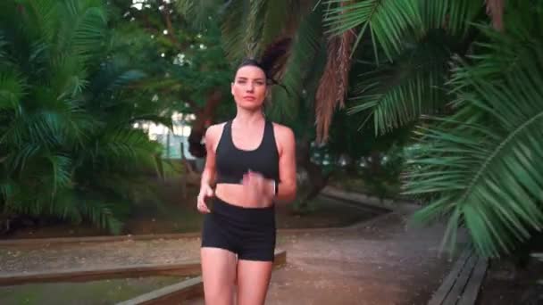 中世の女性都市公園で夏の日ジョギング 白人女性アスリートが屋外を走る 健康的なライフスタイル 朝のジョギングトレーニング 撃たれてる 自信笑顔スポーツ女性の肯定的な感情 — ストック動画