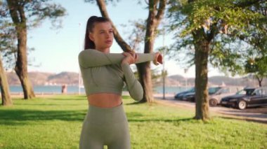 Woman Stretching And Warming-Up Before Running. Fit sport woman stretching her body warm up before workout outdoor. The girl in sportswear exercises outside in summer park for health and wellbeing. 