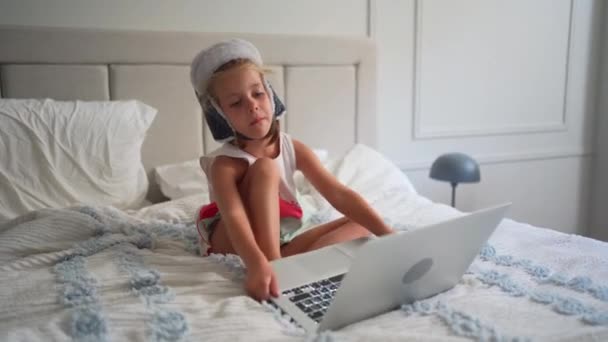 Criança Chapéu Engraçado Assistindo Vídeo Sofá Sentado Laptop Casa Pequena — Vídeo de Stock