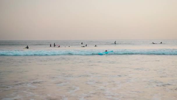 ポルトガル カルカベロス 2022年10月大西洋で波に乗るウェットスーツのサーファーのグループカルカベロスビーチ夏の日 アマチュアサーフィンライダーグループ — ストック動画