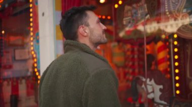 Dışarıdaki dükkan penceresinin yanında duran fotoğrafçı kameraya gülümsüyor. Şehirdeki kentsel çevrede yaşayan çekici bir İspanyol..