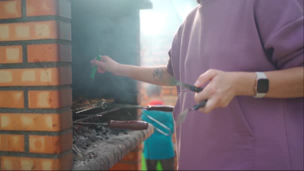 公園でバーベキューグリル屋外を準備女性 白人女性火の上で肉を準備する人 — ストック動画