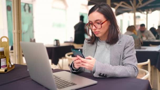 Γυναίκα Που Εργάζονται Φορητό Υπολογιστή Χρήση Smartphone Κάθεται Street Cafe — Αρχείο Βίντεο