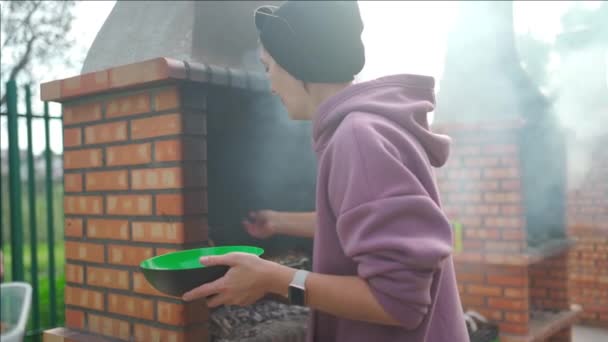 公園でバーベキューグリル屋外を準備女性 白人女性火の上で肉を準備する人 — ストック動画