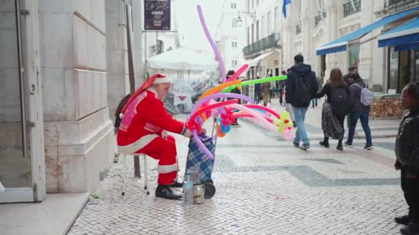 ポルトガルリスボン2022年12月 サンタクロースがカラフルな風船 バルーンキングを販売しています 人々は見て 買って 親と子供 ダウンタウンリスボン 日ヨーロッパ — ストック動画