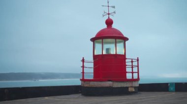 Lighthouse lamp room Nazare, Portugal blue sky and sea background dramatic mood, Cinematic footage of retro lighthouse on Atlantic ocean at evenining dusk Copy space